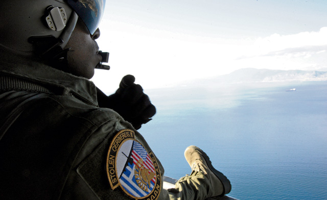 Photo by Senior Airman Nicholas CrispSenior Airman Ralph Colas, 37th Airlift Squadron loadmaster, looks out the back of a C-130J Super Hercules Feb. 3 as it flies over the Greek landscape during Stolen Cerberus II, a flying training deployment in Elefsis, Greece. The FTD is designed to gauge both aircraft and personnel capabilities as well as improve the interoperability of the Airmen and their Greek counterparts.