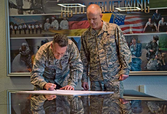 Brig. Gen. Patrick X. Mordente, 86th Airlift Wing commander, signs a Military Saves Week proclamation Feb. 13 on Ramstein as Chief Master Sgt. Frank Batten III, 86th AW command chief, looks on. Military Saves, a component of the nonprofit America Saves and a partner in the Department of Defense’s Financial Readiness Campaign, seeks to motivate, support and encourage military families to save money, reduce debt and build wealth. The proclamation declares Feb. 23 to 27 as Military Saves Week, encouraging service members to set financial goals.