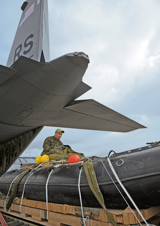 A Hellenic air force airman does a final inspection on a Greek-configured boat rig before it is loaded onto a C-130J Super Hercules assigned to the 37th Airlift Squadron Feb. 6 in Elefsis, Greece. The rig was prepared to be dropped from the C-130 during Stolen Cerberus II.