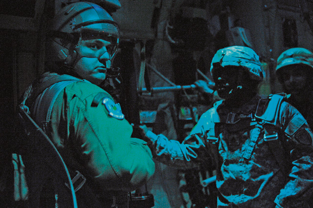 Staff Sgt. Joshua Nelson (left), 37th Airlift Squadron loadmaster, waits to give the “go” signal to U.S. Army jumpmasters and Greek paratroopers on a C-130J Super Hercules.