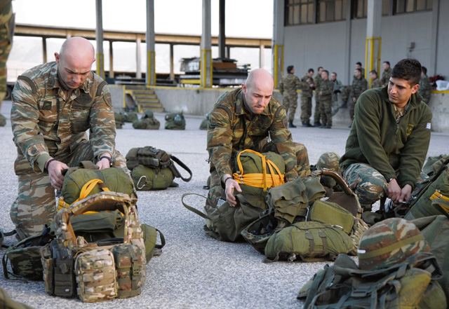 Hellenic air force paratroopers inspect their parachutes  Feb. 4 before boarding a U.S. Air Force C-130J Super Hercules for a night jump.