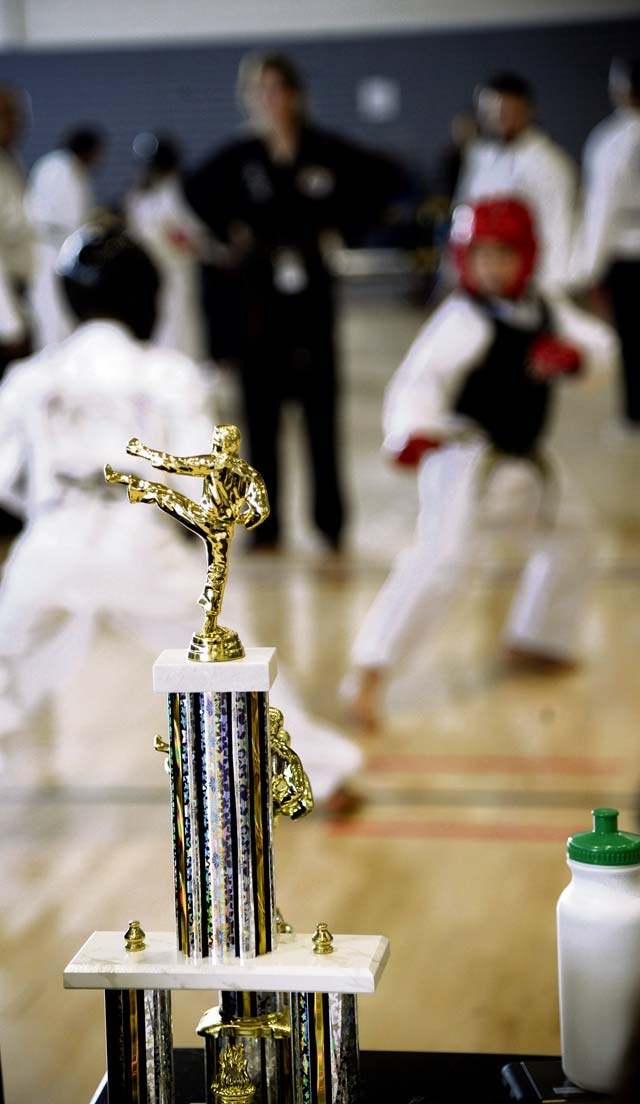 A trophy is on display as two competitors spar at the tournament. Over 200 students from martial arts schools around Europe competed.
