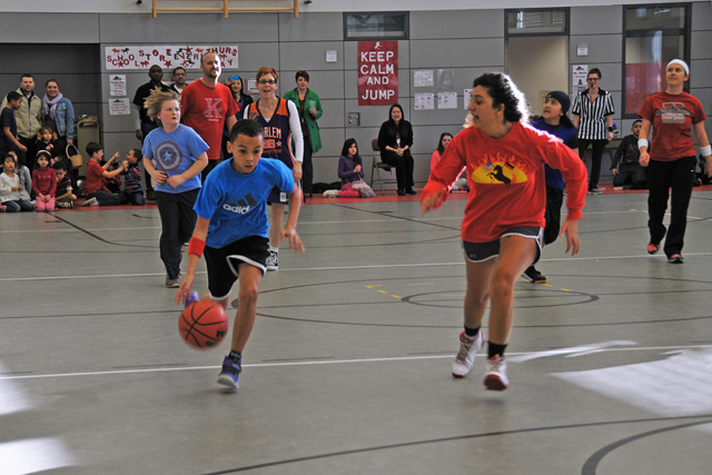 Photo by Heidi BuschStudents vs. staff basketball matchKaiserslautern Elementary School fifth-grader DeShawn Ladipo dribbles the ball past Toni Dailgle during a friendly match of basketball that set KES students against staff members. During the game, which was sponsored by the student council, the fifth-graders beat the staff 18-17 in a last-second shot.