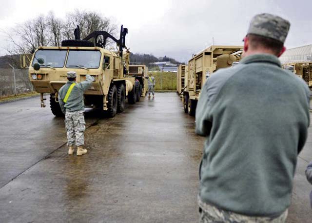 An Air Force officer observes as Soldiers from the 21st Theater Sustainment Command’s 240th Quartermaster Company, 18th Combat Sustainment Support Battalion, 16th Sustainment Brigade load a mobile refrigeration unit onto a palletized load system during a professional development session Feb. 26 on Baumholder’s Smith Barracks. 