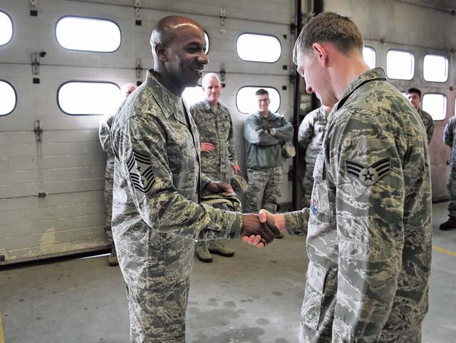 Chief Master Sgt. Kaleth Wright, 3rd Air Force command chief, presents a coin to Senior Airman Kyle Ledford, 86th Civil Engineer Squadron firefighter, during the chief’s immersion tour March 2 at Ramstein. Airmen demonstrated their capabilities and spoke to Wright  about his experiences and Air Force current events.