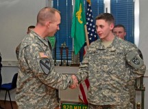 Pvt. Connor Stennett, a military policeman with the 92nd MP Company, 709th MP Battalion, 18th MP Brigade, receives a coin from Command Sgt. Maj. Rodney J. Rhoades, the senior enlisted leader of the 21st Theater Sustainment Command, during a gathering March 5 on Sembach Kaserne.
