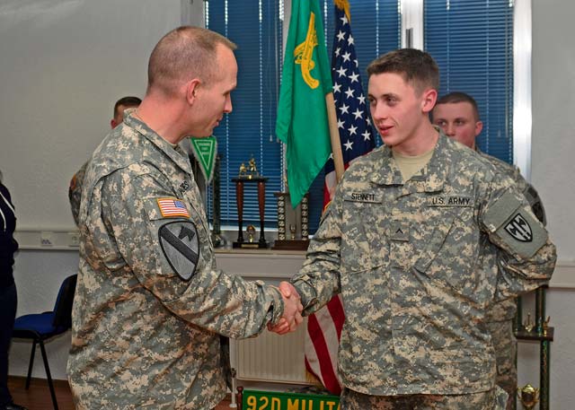 Pvt. Connor Stennett, a military policeman with the 92nd MP Company, 709th MP Battalion, 18th MP Brigade, receives a coin from Command Sgt. Maj. Rodney J. Rhoades, the senior enlisted leader of the 21st Theater Sustainment Command, during a gathering March 5 on Sembach Kaserne. 