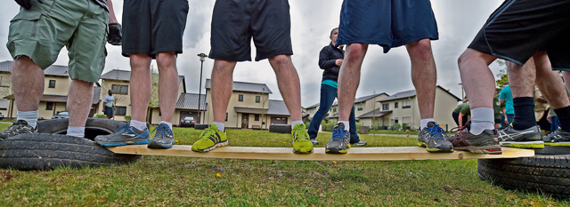 A team balances on a board as they attempt to complete the final obstacle.