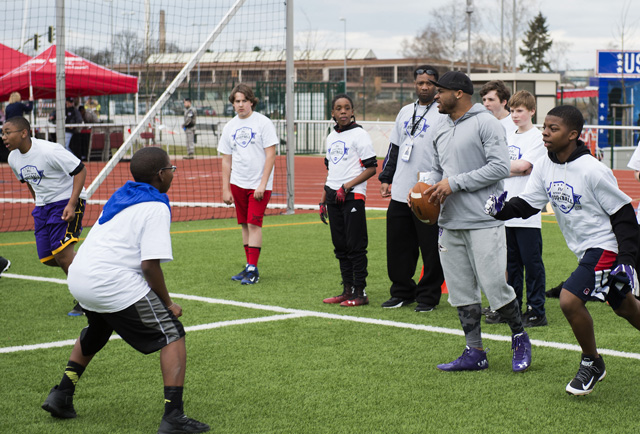 Steve Smith, Baltimore Ravens wide receiver, looks for an open teammate to pass the ball to during a ProCamps event April 11, on Vogelweh. Smith, three-time All-Pro NFL wide receiver, played all-time quarterback during the camp, jumping into different scrimmages to throw touchdown passes to children.