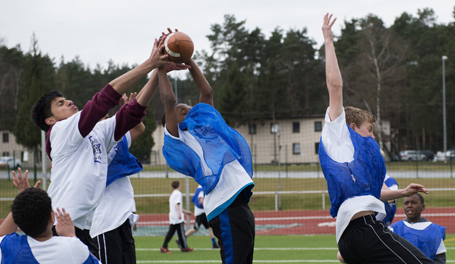 Darrick Henderson Jr., center, son of Zachary Warren, intercepts a pass April 11, 2015, at Vogelweh Military Complex, Germany. During the camp, attendees learned the fundamentals of football through drills, skill development, seven-on-seven games and interactions with local coaches. (U.S. Air Force photo/Senior Airman Damon Kasberg)
