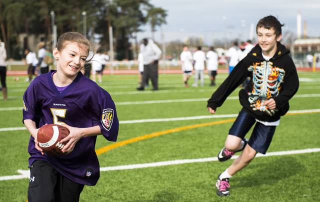 Anya Chervak, daughter of Steven Chervak, runs past a defender during a ProCamps event April 11, 2015, at Vogelweh Military Complex, Germany. Attendees of the camp had the opportunity to meet Steve Smith, Baltimore Ravens wide receiver, who demonstrated football techniques, autographed shirts and participated in scrimmages. (U.S. Air Force photo/Senior Airman Damon Kasberg)