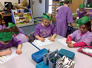 Courtesy Photo by Elsa Tovar, kindergarten teacher Month of the Military Child: Students in Elsa Tovar’s kindergarten class at Landstuhl Elementary Middle School, work on a writing activity during the Patch of Honor Contest and Purple Up celebrated on April 15.
