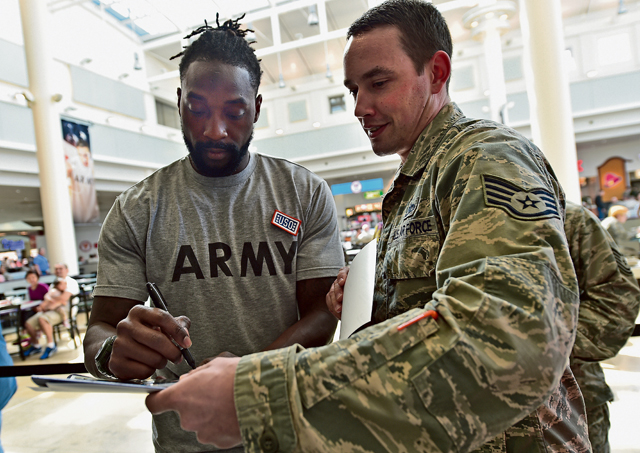  Charles Tillman, an NFL cornerback who was the Walter Payton Man of the Year in 2013, signs his autograph for an Airman during the USO’s ProTour 2015, April 15 on Ramstein. 