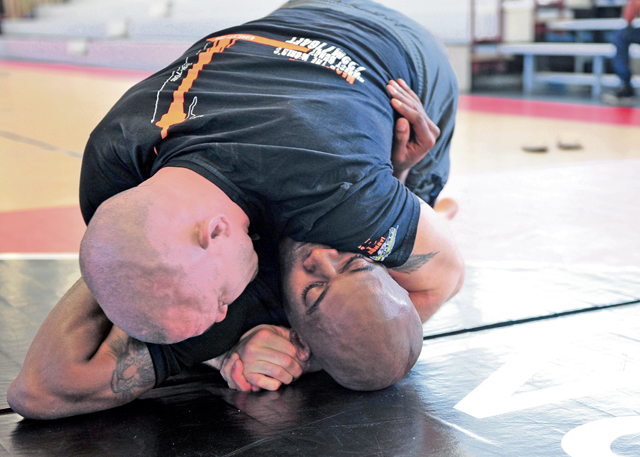 Sgt. 1st Class Ronnell Foster (bottom), a 21st Theater Sustainment Command combatives instructor,  grapples with mixed martial arts fighter Chris Lytle  (top) during his visit April 15 to Kleber Kaserne, Germany.