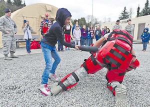 Kinnis Thompson, a Ramstein Intermediate School student, takes down a posed assailant during the less-than-lethal force baton training. Security Forces also displayed weapons, tactical gear and a patrol vehicle.