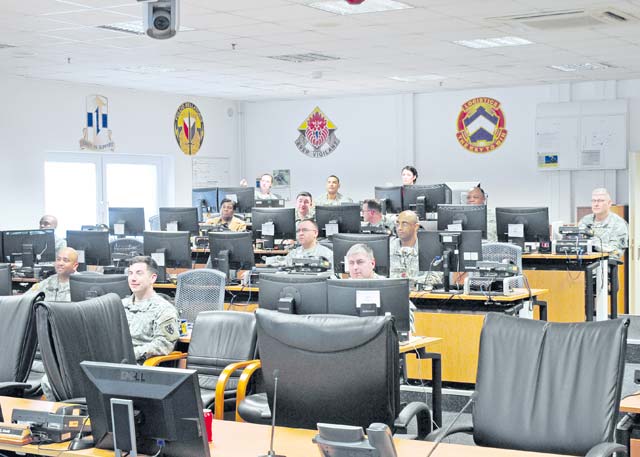 Staff members from throughout the 21st Theater Sustainment Command look on as they are briefed on current operations going on across the command’s area of operations during an operations update brief March 27. The staff conducted the first phase of a staff exercise designed to assess and improve staff proficiencies on select training tasks.