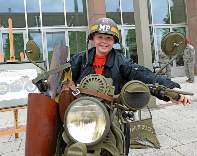 A child sits on a vintage military police motorcycle during a display held in honor of National Police Week. Patrons were also able to sit in police cars and a mine-resistant, ambush-protected vehicle during the event.