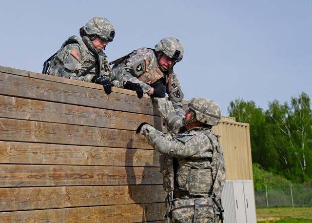 Photo by Staff Sgt. Warren W. Wright Jr. Best Warrior candidates work as a team to navigate a wall obstacle May 12 during the medical simulation portion of the 2015 Best Warrior Competition held May 10 through 14 at Camp Aachen. First-place warriors in junior officer, noncommissioned officer and junior Soldier categories will compete in the U.S. Army Europe BWC.
