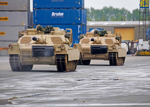 Photo by Staff Sgt. Warren W. Wright Jr.  Two M1 Abrams tanks move down the docks of Antwerp toward their holding area after being offloaded from the freighter “Resolve,” April 24.  