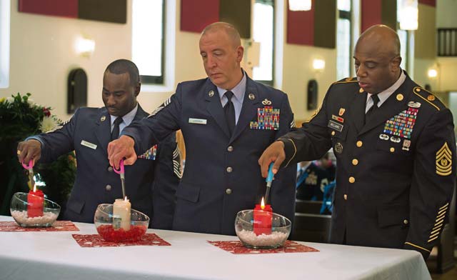 U.S. Air Force and Army service members light a candle to honor the memories of deceased children during the Kindergraves memorial service May 16 in Kaiserslautern. Representatives from Ramstein and the host nation serve as co-chairs for the Kaiserslautern Kindergraves Memorial Foundation which maintains open communication with families, preserves historical archives, conducts ceremonies and provides oversight to site maintenance.