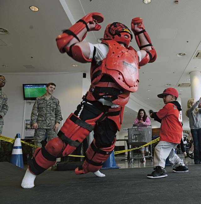 A Security Forces Airman teaches a child hands-on self-defense during a display held in honor of National Police Week.