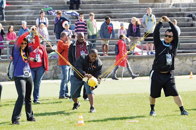 Photo by Linda Steil Spc. Aaron Wilson places the ball while teammates Brittany Kelly and Viah Ngwyen hold the slingshot in the target shooting section of the “Amazing Race.”