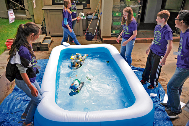 Middle school students test their hand-crafted boats during the STEMposium challenge.