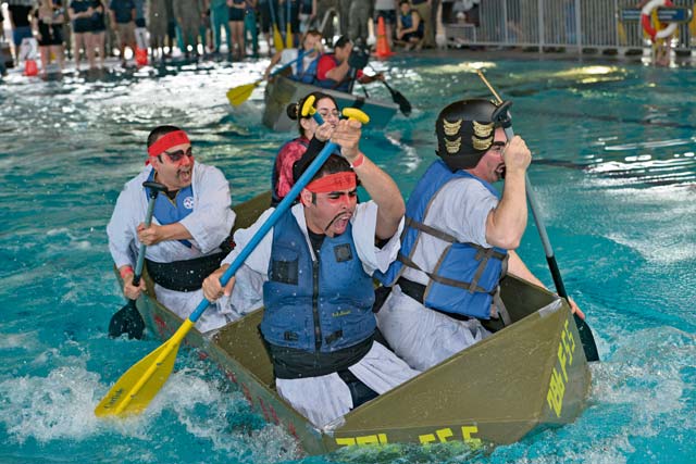 Participants from the 786th Force Support Squadron paddle pass the other teams during the Battle of the Battleships competition May 15 on Ramstein. The competition began with boat races, where teams were tasked to pedal their custom-built boats from one end of the pool to the other as quickly as possible.