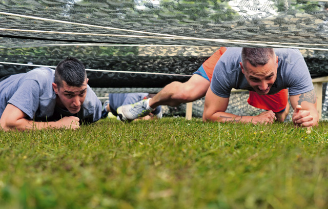 Members of team "Dirty Laundry" compete in the low crawl obstacle during the Mudless Mudder.