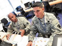 Sgt. Roger Lopez (right), the 1st Human Resources Sustainment Center postal NCOIC, and Spc. Brandon Vines, a 1st HRSC human resources specialist, review and discuss postal plans May 20 during Iron Will 15.