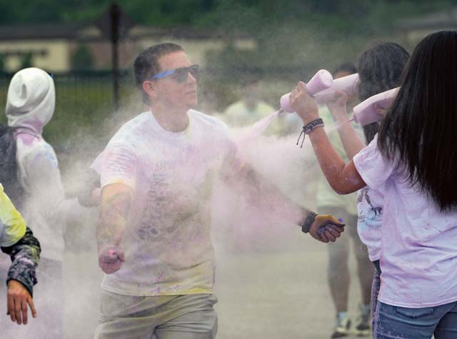 A participant in the Keystone 5K Color Run willingly accepts a blast of colored powder as he passes through a color station. 