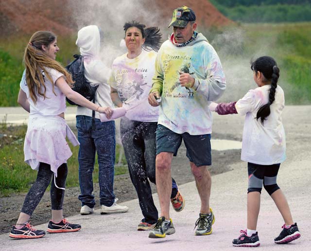 KMC members get doused in colored powder during the color run. Color run volunteers set up color stations at various places along the route to ensure participants were thoroughly covered.