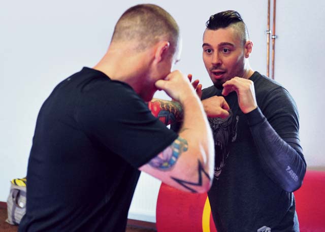 Dan “The Outlaw” Hardy (right), an accomplished veteran of the Ultimate Fighting Championship, demonstrates a movement technique with Staff Sgt. David Maybury, 7th Civil Support Command, 21st Theater Sustainment Command master combatives trainer during a mixed martial arts seminar June 2 on Ramstein.