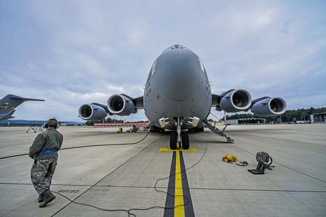 Staff Sgt. Adam Hart, 721st Aircraft Maintenance Squadron electrical and environmental systems specialist, refuels a C-17 Globemaster III before a flight to Bulgaria June 20 on  Ramstein.  Airmen and Soldiers worked together to load two M1A2 Abrams main battle tanks onto the aircraft. 