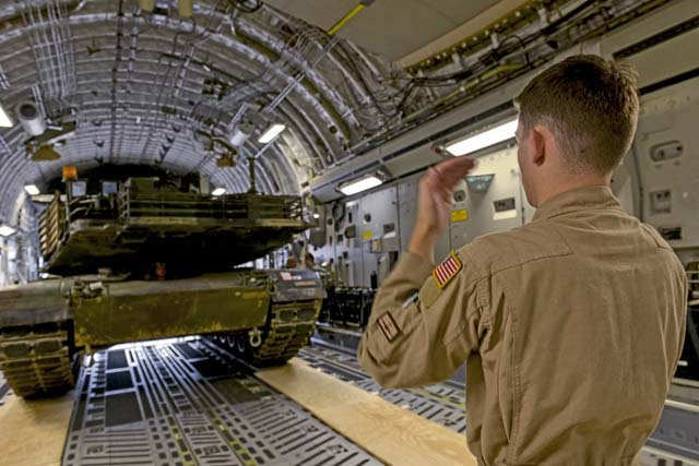 Airman 1st Class Kenneth Whitler, 7th Airlift Squadron aircraft loadmaster from Joint Base Lewis-McChord, Washington, directs an M1A2 Abrams main battle tank onto a C-17 Globemaster III June 20 on Ramstein.  Airmen and Soldiers from across the U.S. European Command theater worked together to transport two tanks weighing 140 tons total to Bulgaria to participate in multinational training in support of Operation Atlantic Resolve.