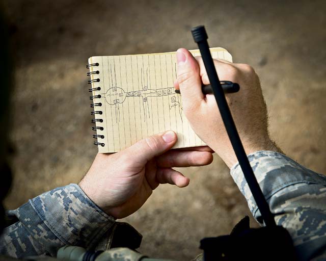 Photo by Tech. Sgt. Daylena S. Ricks A student sketches from the sand table for a mission rehearsal during the Base Security Operations course June 15 on Baumholder. Sand tables are used to conduct rehearsals prior to missions.