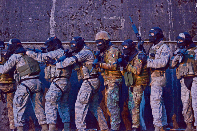 U.S. Airmen and Italian soldiers position themselves alongside a training hangar before breaching and clearing it during Battlefield Leaders Assaulter Course, Integrated Combat Essentials  May 30 on Ramstein. BLAC ICE brings together security forces members from Belgium, Germany, the Netherlands and Italy to promote a wider training standard among allied nations.