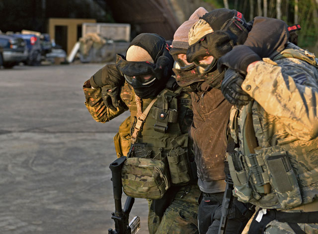 Two U.S. Airmen carry out another Airman simulating an opposing force member. The training covers advanced tactics, such as properly removing bodies or incapacitated individuals.