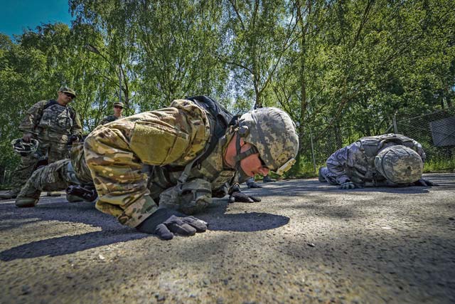 Master Sgt. Kevin Maloney, 86th Security Forces Squadron flight chief, performs push-ups during live-fire, stress-fire training June 15 on Baumholder. The students fire with no stress, then fire after completing strenuous exercises until fatigued. 