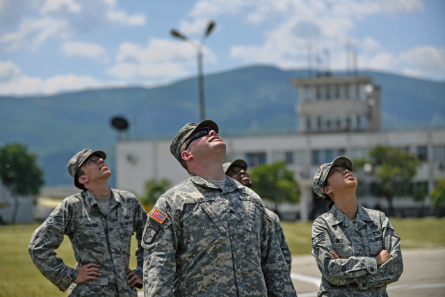 Airmen and Soldiers watch as paratroopers parachute over Krumuvo Air Base, Bulgaria, July 16. The airdrop was part of a demonstration that showcased not only personnel drops but also emergency medical evacuation procedures.