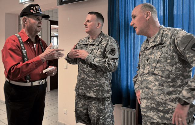 Retired Maj. James M. Beckworth, a 25-year veteran who served with the 3rd Infantry Division among other organizations, discusses his military career with Col. Todd Bertulis, commander of the 409th Army Field Support Brigade 21st Theater Sustainment Command (right), and Command Sgt. Maj. Stanley Richards, 409th AFSB command sergeant major, at the Clock Tower Cafe on Kleber Kaserne July 15.