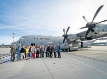 German local nationals who work on Ramstein pose for a group photo in front of a C-130J Super Hercules before an orientation flight June 29 on Ramstein.