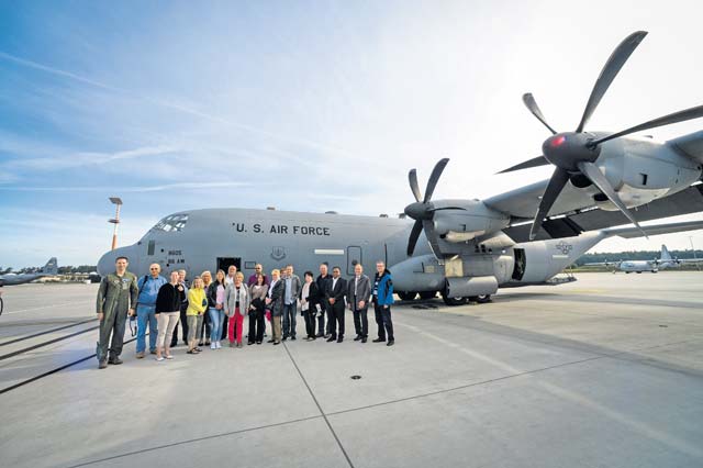 German local nationals who work on Ramstein pose for a group photo in front of a C-130J Super Hercules before an orientation flight June 29 on Ramstein.