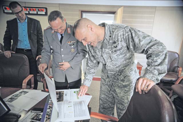 German Armed Forces Lt. Col. Michael Brendel, Leadership Development and Civic Education Center Koblenz senior civil servant (left), shows training slides to Brig. Gen. Bradley Spacy, U.S. Air Forces in Europe and Air Forces Africa director of Logistics, Installations and Mission Support and Diversity and Inclusion Council chair, during a Diversity and Inclusion Council meeting June 26 on Ramstein.