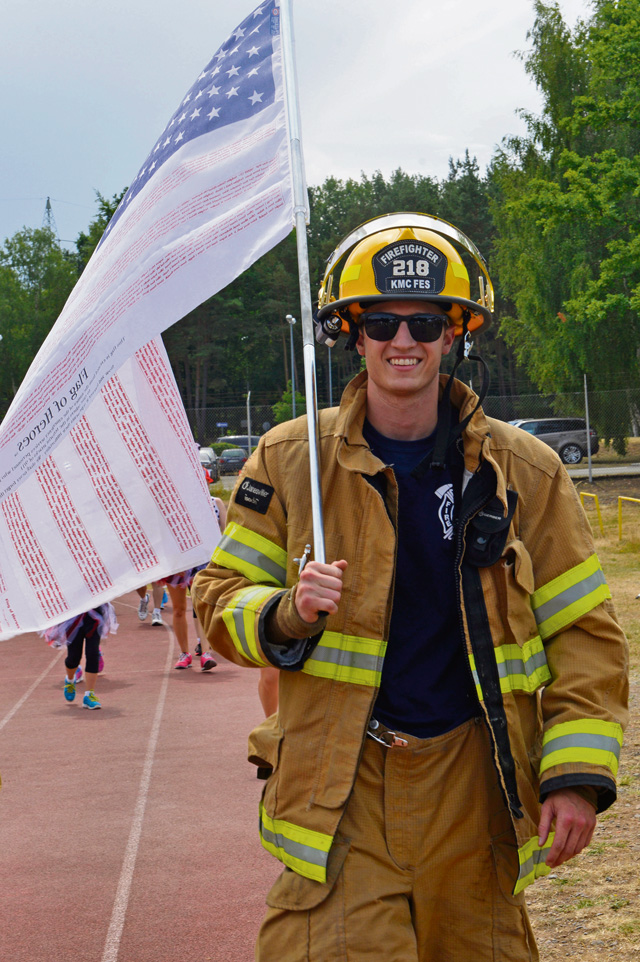 Airman 1st Class Adam Harkins, 86th Civil Engineer Squadron firefighter, carries a flag during the 2015 Viking Challenge July 17 at Pulaski Park.