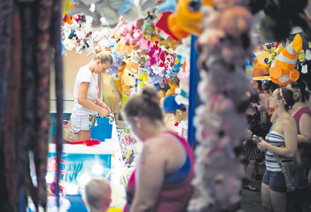 A carnival employee prepares a prize for a winner at Freedom Fest.