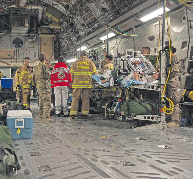 Firefighters and medical personnel standby to assist in the transport of a patient during an aeromedical evacuation mission Aug. 9 on Ramstein. The personnel assisting in the mission were from the 86th Civil Engineer Squadron KMC Fire Emergency Services, the 10th Aeromedical Evacuation Operations Team and the 455th Critical Care Air Transport Team.