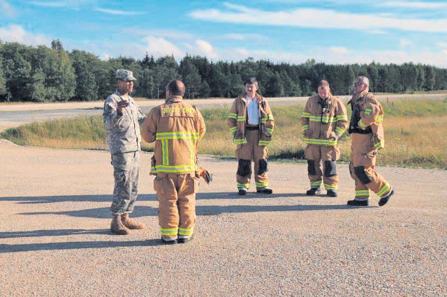 Photos by Staff Sgt. Jerry Boffen Capt. Matthew D. Pride, lead planner for exercise Swift Response 15, Joint Multinational Readiness Center, discusses safety plans with German firefighters prior to testing the recently resurfaced and extended short takeoff and landing strip at Hohenfels.