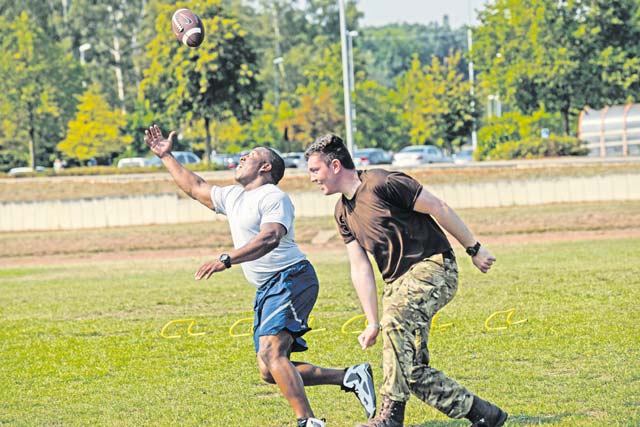 Staff Sgt. Darryl Brown, 786th Civil Engineer Squadron NCOIC of vehicle control, and a Royal Air Force Air Training Corps cadet play football during an obstacle course Aug. 10 on Vogelweh.