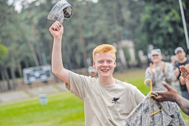 Jack Mottram, Royal Air Force Air Training Corps cadet, receives an Airman Battle Uniform cover from a Kisling NCO Academy instructor. It is tradition within the RAF to collect and exchange hats from different missions.
